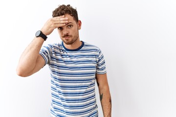 Fototapeta premium Handsome young man standing over isolated background worried and stressed about a problem with hand on forehead, nervous and anxious for crisis
