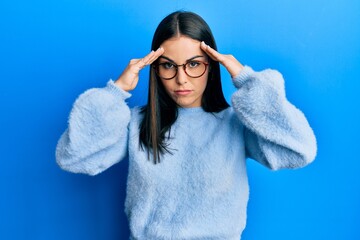 Young brunette woman wearing casual clothes and glasses with hand on head, headache because stress....