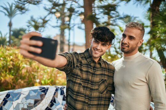 Young gay couple smiling happy making selfie by the smartphone at the city.