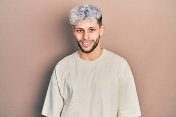 Young hispanic man with modern dyed hair wearing casual t shirt with a happy and cool smile on face. lucky person.