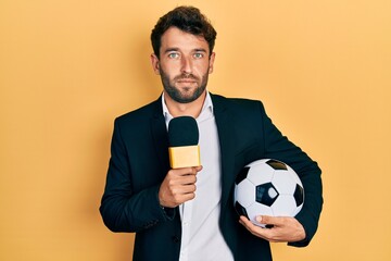 Handsome man with beard football reporter microphone relaxed with serious expression on face....