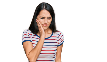 Young hispanic girl wearing casual striped t shirt touching mouth with hand with painful expression because of toothache or dental illness on teeth. dentist