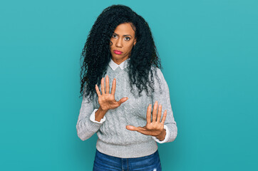 Middle age african american woman wearing casual clothes moving away hands palms showing refusal and denial with afraid and disgusting expression. stop and forbidden.
