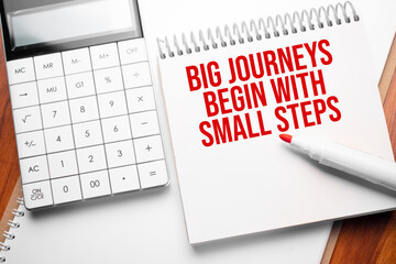 Notepad with text Big journeys begin with small steps on wooden background with calculator and red marker