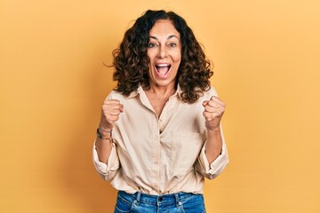 Middle age hispanic woman wearing casual clothes celebrating surprised and amazed for success with...