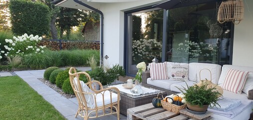 Komplet wypoczynkowy na tarasie w ogrodzie,  taras i nowoczesne  meble ogrodowe z rattanu z poduszkami - obrazy, fototapety, plakaty