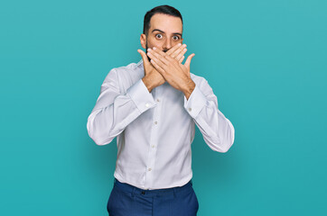 Young man with beard wearing business shirt shocked covering mouth with hands for mistake. secret concept.