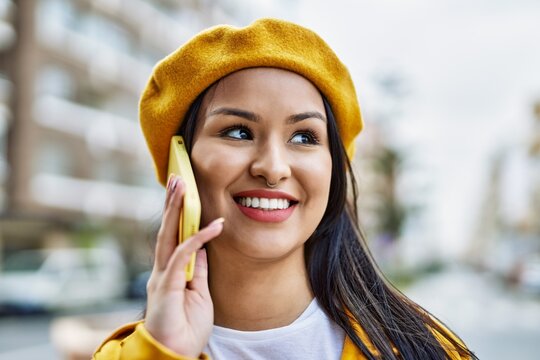 Young latin girl smiling happy talking on the smartphone at the city.