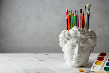 David's head plaster stand for office, creative and school supplies on a light background....