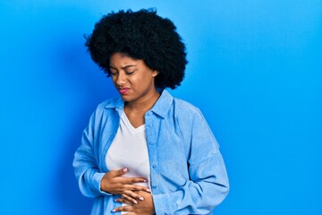 Young african american woman wearing casual clothes with hand on stomach because indigestion, painful illness feeling unwell. ache concept.