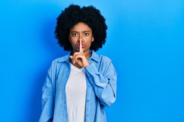 Fototapeta na wymiar Young african american woman wearing casual clothes asking to be quiet with finger on lips. silence and secret concept.