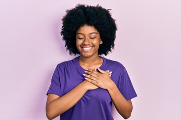 Young african american woman wearing casual clothes smiling with hands on chest with closed eyes...