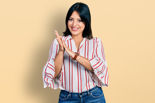 Young hispanic girl wearing casual clothes clapping and applauding happy and joyful, smiling proud hands together