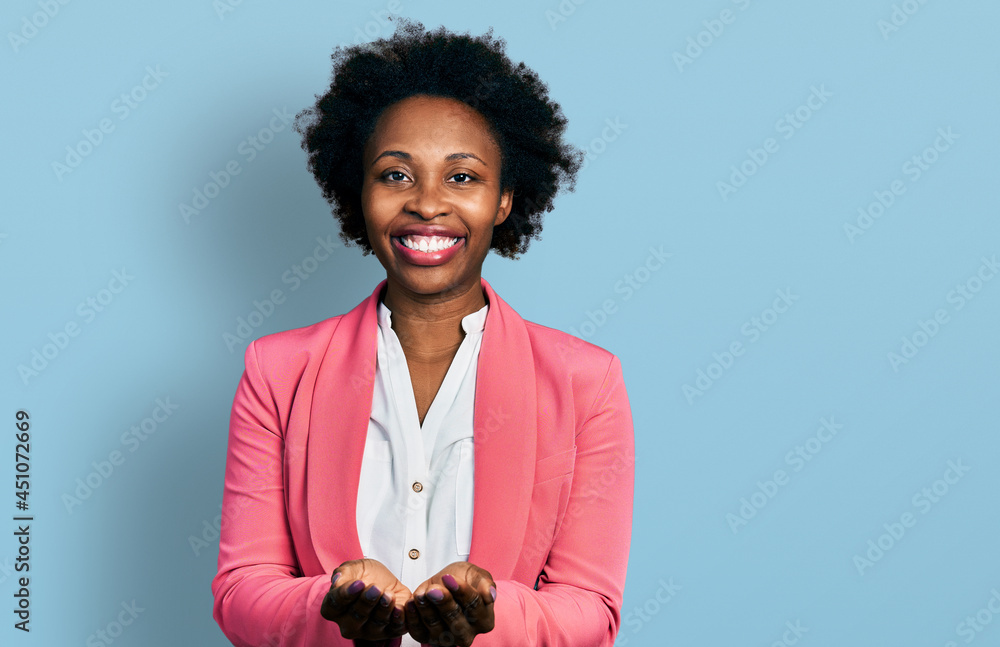 Canvas Prints African american woman with afro hair wearing business jacket smiling with hands palms together receiving or giving gesture. hold and protection