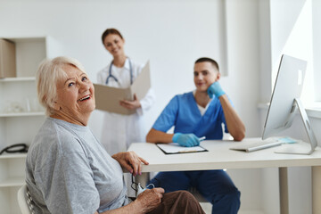 Cheerful elderly woman at the doctor's and nurse's appointment in the hospital