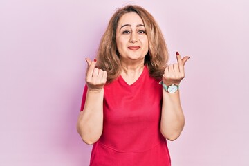 Middle age caucasian woman wearing casual clothes doing money gesture with hands, asking for salary payment, millionaire business