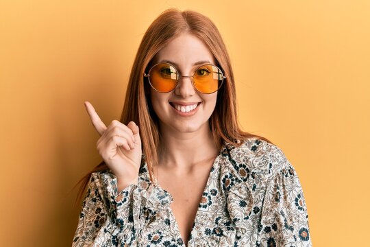 Young irish woman wearing bohemian and hippie style smiling happy pointing with hand and finger to the side