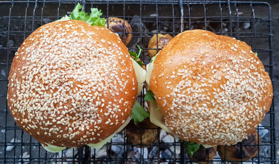 Close-up of two large DIY hamburgers in the park on a barbecue, rest and cooking on a picnic in the summer, food, delicious, bright colors. Unhealthy food concept. Fast food. Flat lay.