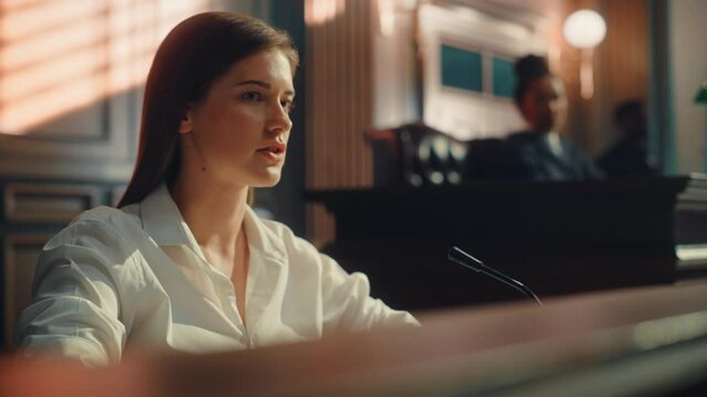 Court of Law and Justice Trial: Portrait of Beautiful Female Witness Giving Evidence to Prosecutor and Defence Counsel, Judge and Jury Listening. Dramatic Speech of Empowered Victim against Crime.