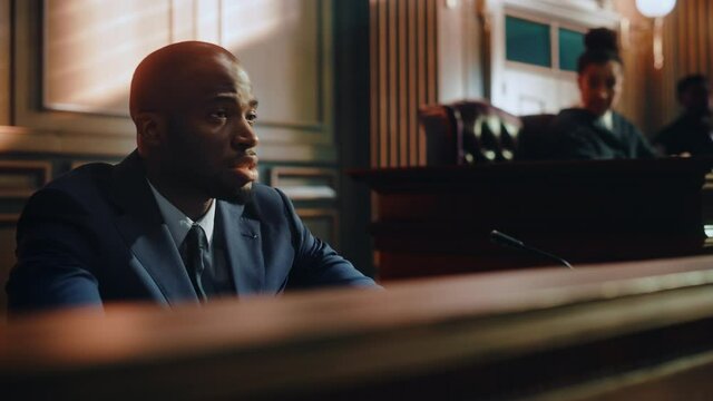 Court of Law and Justice Concept. Portrait of Handsome African American Male Witness Giving Testimony to Imparcial Judge, Jury. Confession of the Accused telling His Story, Repenting.