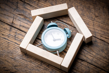 house symbol made wooden blocks with alarm clock inside. above view. outer space