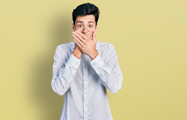 Young hispanic business man wearing business clothes shocked covering mouth with hands for mistake. secret concept.