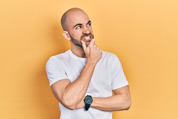 Young bald man wearing casual white t shirt thinking worried about a question, concerned and nervous with hand on chin