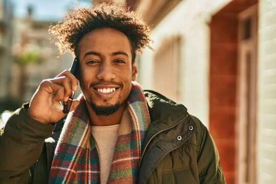 Young african american man smiling happy talking on the smartphone at the city