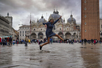 Naklejka na ściany i meble Young woman walking through St. Mark's Square, Venice, Italy.