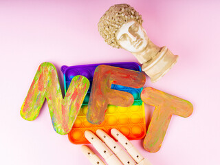 NFT Non-Fungible token. Concept for blockchain system. Classical statue and Pop it toy on a pink background. Crypto art concept with an artificial hand