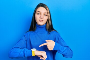 Young brunette girl wearing turtleneck sweater in hurry pointing to watch time, impatience, upset and angry for deadline delay