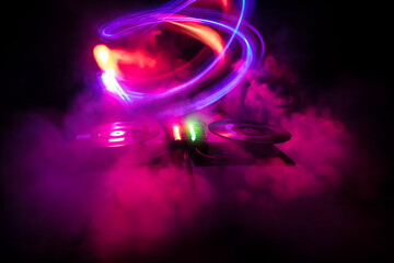 Dj club concept. Creative artwork decoration of dj table on dark toned background with lights and...