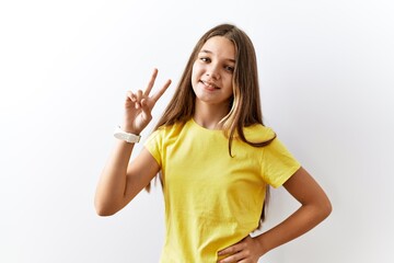 Fototapeta premium Young brunette teenager standing together over isolated background smiling looking to the camera showing fingers doing victory sign. number two.