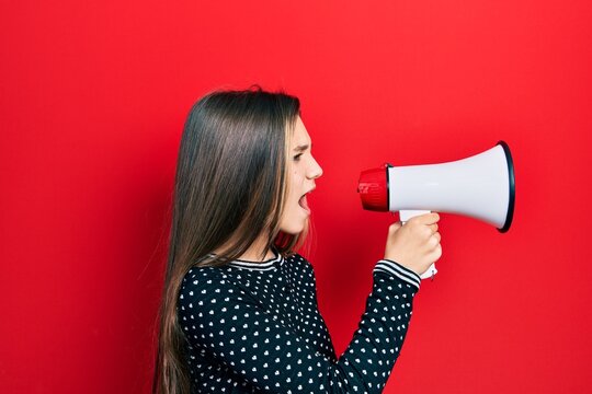 Young teenager girl shouthing and screaming with megaphone