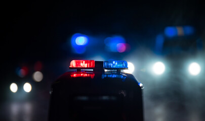 Obraz na płótnie Canvas Police cars at night. Police car chasing a car at night with fog background. 911 Emergency response police car speeding to scene of crime.