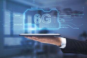 Close up of businessman hand holding tablet with creative 6G chip hologram on blurry office interior background. Wireless information and future concept. Double exposure.
