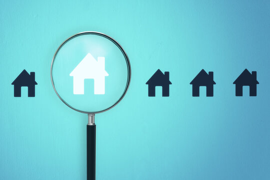 Magnifier zooming in on house icon on blue background. Home and property search concept. 3D Rendering.