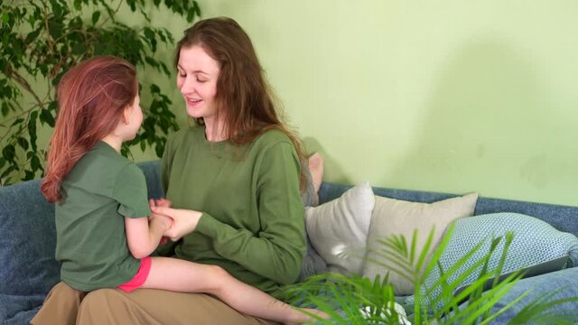 Close relationship. Affectionate young Mom and daughter hug on couch home. happy family. Parenthood. girl kiss woman. Sisters talk and laugh. Mothers Day congratulate love. Have fun. sofa enjoy time