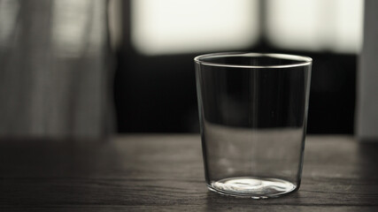 Empty tumbler glass on oak table