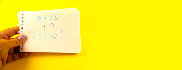 school, notepad with the inscription back to school, stationery against yellow background with...