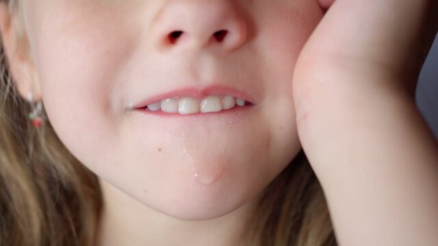 girl opens her mouth wide and pulls out long tongue. child shows his teeth soft palate and mouth to dentist. mouth is wide open, tongue is stuck out as far as possible, with clear view of tongue