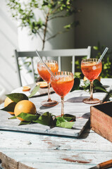 Aperol Spritz cocktail in glasses with fresh orange on table - 451084421