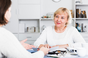 Mature woman consults with a financial adviser for the proper conduct of home accounting