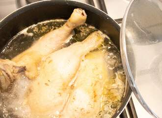chicken is cooking in a pot on the stove