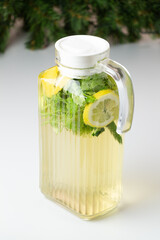 Detox water in jug on white background. Lemon, green apple, parsley, cucumber, green tea and water in pitcher on white background.