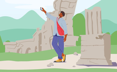 Young Man with Backpack Making Selfie on Smartphone on Ancient Ruins Background . Traveling to Foreign Country