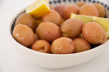 green olives in bowl on white background