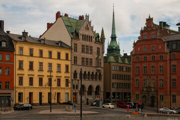 Fototapeta na wymiar Colorful buildings and a church top of Stockholm's Gamla Stan, Sweden