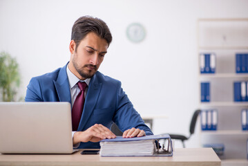 Obraz premium Young male employee working at workplace