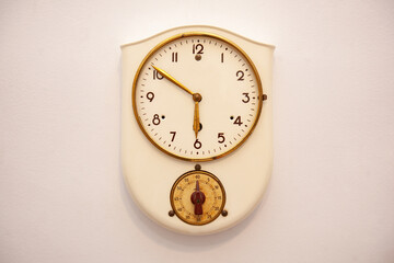 
old classic beige clock hanging on the wall